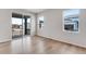 Bright living room with wood floors and sliding glass door leading to a porch at 10661 Reunion Pkwy, Commerce City, CO 80022