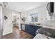 Modern kitchen featuring navy and white cabinetry, granite countertops, stainless steel appliances, and hardwood floors at 1182 S Alcott St, Denver, CO 80219