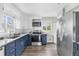 Contemporary kitchen with navy-blue lower cabinets, white upper cabinets, stainless-steel appliances, and hardwood floors at 1182 S Alcott St, Denver, CO 80219