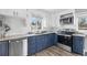 Modern kitchen boasting white upper cabinets and navy-blue lower cabinets with stainless-steel appliances and hardware at 1182 S Alcott St, Denver, CO 80219
