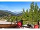 Deck with red chairs boasting forest views and clear blue skies at 1575 York Gulch Rd, Idaho Springs, CO 80452