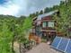 Wooden multi-story house with solar panels nestled among tall pine trees at 1575 York Gulch Rd, Idaho Springs, CO 80452