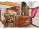 Open living room with a stone fireplace, wood beams, and unique wooden staircase at 1575 York Gulch Rd, Idaho Springs, CO 80452