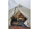 A rustic tent interior featuring a bed, chairs, and wood-burning stove, creating a cozy camping retreat at 1575 York Gulch Rd, Idaho Springs, CO 80452