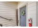 Gray front door with a decorative wreath, a seasonal floral arrangement and safety equipment at 7292 S Blackhawk St # 2-204, Englewood, CO 80112