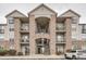 Multi-story condominium featuring a stone facade, balconies, and accessible parking at 7292 S Blackhawk St # 2-204, Englewood, CO 80112