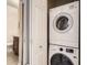 Efficient laundry area with stacked washer and dryer, and door to hall bathroom at 7292 S Blackhawk St # 2-204, Englewood, CO 80112