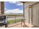 Relaxing balcony with a grill, small table, and expansive views of a green field and distant buildings at 7292 S Blackhawk St # 2-204, Englewood, CO 80112