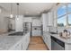 Bright kitchen with white cabinets, granite countertops, stainless steel appliances, and wood flooring at 265 Calhoun Cir, Castle Rock, CO 80104