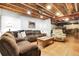 Finished basement with a cozy seating area, exposed ceiling, and warm lighting at 484 N Jamestown Way, Aurora, CO 80018