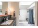 Modern bathroom featuring a stylish vanity, and a walk-in shower with a blue curtain at 995 Chase St, Lakewood, CO 80214