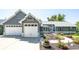 Charming gray house boasts an attached 2-car garage and a walkway with flowers in the front yard at 995 Chase St, Lakewood, CO 80214