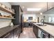 Contemporary kitchen with black and white cabinetry, open shelving, and stainless steel appliances at 995 Chase St, Lakewood, CO 80214