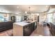 Modern kitchen featuring dark cabinets, quartz countertops, an island, and a dining nook at 995 Chase St, Lakewood, CO 80214