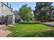 A large grassy backyard space with a line of townhomes and tall, mature trees at 2291 S Jasper Way # B, Aurora, CO 80013