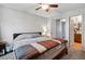 This carpeted bedroom has a ceiling fan and leads to a bathroom through an open door at 2291 S Jasper Way # B, Aurora, CO 80013