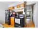 Open kitchen featuring a black stove and refrigerator, wood cabinets, and a seamless transition to the living area at 2291 S Jasper Way # B, Aurora, CO 80013