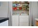 Convenient laundry area with a washer and dryer, neatly arranged shelving, and practical storage solutions at 2291 S Jasper Way # B, Aurora, CO 80013