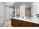 Modern bathroom with double sinks, wood cabinets, recessed lighting and a shower at 4200 W 17Th Ave # 621, Denver, CO 80204