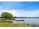 Picturesque view of the tranquil lake with a wooden pier, surrounded by lush greenery and a clear blue sky at 4200 W 17Th Ave # 621, Denver, CO 80204