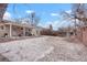 Wide shot of fenced backyard featuring patio, grassy area, and some snow cover at 3401 S Glencoe St, Denver, CO 80222