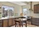 Bright kitchen features stainless steel appliances, wood cabinetry, and natural light from large window above the sink at 15525 W La Salle Ave, Lakewood, CO 80228