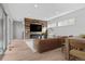 Staged open-concept living room features a modern fireplace, hardwood floors, and stylish furniture with a rustic accent wall at 15525 W La Salle Ave, Lakewood, CO 80228
