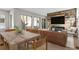 Bright open-concept living room features hardwood floors, modern furnishings, and a rustic wood accent wall with a fireplace at 15525 W La Salle Ave, Lakewood, CO 80228