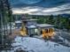 Aerial view of a modern house with a three-car garage surrounded by lush greenery and a beautiful landscape at 11505 Conifer Ridge Dr, Conifer, CO 80433