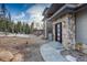 Striking home showcasing natural stone and a modern entrance, complemented by an inviting pathway and landscape at 11505 Conifer Ridge Dr, Conifer, CO 80433