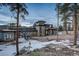 Contemporary home featuring stone accents, large windows and a scenic snow covered landscape at 11505 Conifer Ridge Dr, Conifer, CO 80433