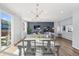Dining area with modern lighting, light grey table, and view of the backyard through sliding glass doors at 1828 Blue Oak Ct, Castle Rock, CO 80104