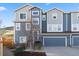 Townhouse exterior with blue siding, stone accents, a well-manicured lawn, and a two-car garage at 1828 Blue Oak Ct, Castle Rock, CO 80104