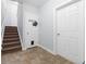 Hallway with carpeted stairs, tile floor, and coat hook by the door at 1828 Blue Oak Ct, Castle Rock, CO 80104