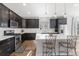 Well-lit kitchen with granite counters, stainless appliances, an island, and modern dark cabinets at 1828 Blue Oak Ct, Castle Rock, CO 80104