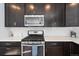 Close-up of modern kitchen's gas range, microwave, and subway tile backsplash with quartz counters at 1828 Blue Oak Ct, Castle Rock, CO 80104