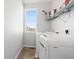 Bright laundry room with window, tile floor, and shelving above a white washer and dryer set at 1828 Blue Oak Ct, Castle Rock, CO 80104