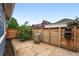 Cozy backyard area with stone patio, wood fence, green tree and plants, and sitting chair with flowers at 3644 Wabash St, Denver, CO 80238