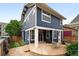 The home's backyard features a stone patio, outdoor seating, green grass, wood fence, and a blue home exterior at 3644 Wabash St, Denver, CO 80238