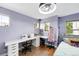 Bright bedroom with purple walls, hardwood floors, large desk, and sewing station at 3644 Wabash St, Denver, CO 80238