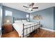 Bedroom with blue walls, ceiling fan, a queen-size bed, hardwood floors, and a mountain decor element at 3644 Wabash St, Denver, CO 80238