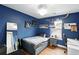 Cozy blue bedroom with hockey-themed decor, hardwood floors, and a comfortable bed at 3644 Wabash St, Denver, CO 80238
