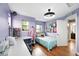 Bright bedroom with hardwood floors, bed, desk and sewing station with purple walls at 3644 Wabash St, Denver, CO 80238