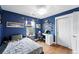 Inviting blue bedroom with hardwood floors, hockey decor, study desk and closet at 3644 Wabash St, Denver, CO 80238