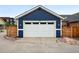 Close-up of the two-car garage, complemented by a wooden fence for added privacy and charm at 3644 Wabash St, Denver, CO 80238