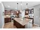 Well-lit kitchen featuring stainless steel appliances, dark wood cabinets, and a center island with pendant lighting at 3644 Wabash St, Denver, CO 80238