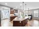 Lovely kitchen with stainless steel appliances, dark cabinets, island with pendant lights, and adjacent dining area at 3644 Wabash St, Denver, CO 80238