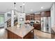 Beautiful kitchen with stainless steel appliances, dark cabinets, island with pendant lighting, and staircase access at 3644 Wabash St, Denver, CO 80238