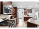 Modern kitchen features stainless steel appliances, dark cabinetry, tile backsplash, and wood flooring at 3644 Wabash St, Denver, CO 80238