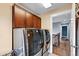 Laundry room featuring front load washer and dryer, cabinets, and hardwood flooring, offering convenience and style at 3644 Wabash St, Denver, CO 80238